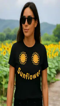 Woman wearing a black t-shirt with yellow sunflower design and text on a city street.